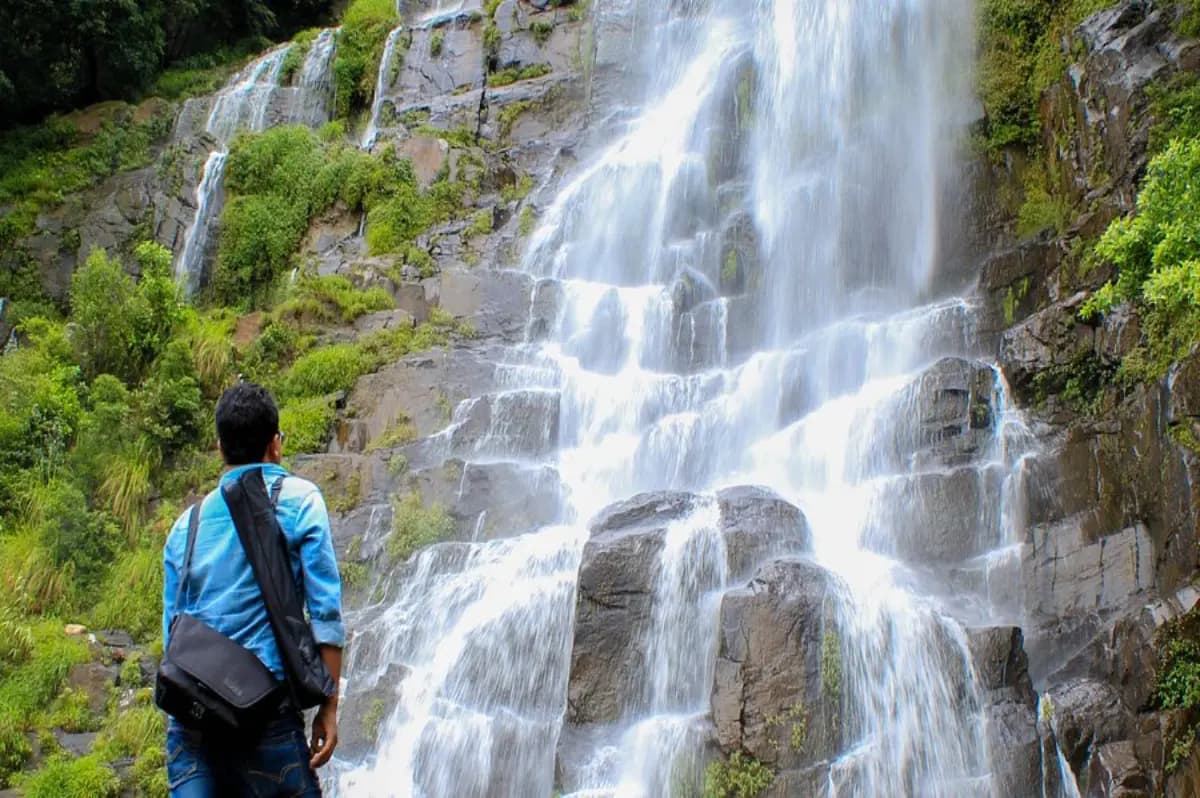Man Standing in front Tyrshi Waterfall