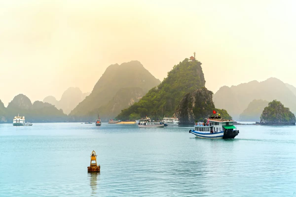Beautiful Tourist cruise ship floating among limestone rocks at Ha Long Bay