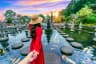 Women tourists holding man's hand and leading him to Tirta Gangga