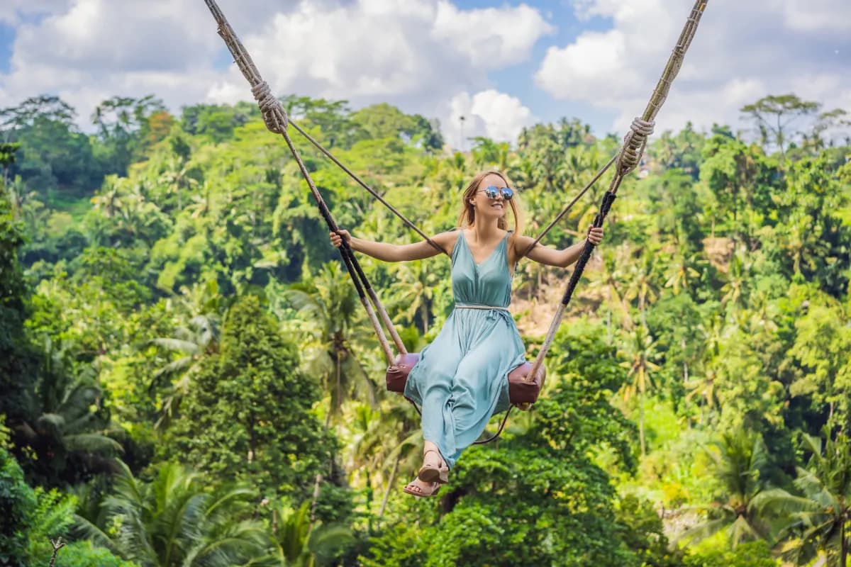 Young woman swinging in the jungle rainforest of Bali island, Indonesia