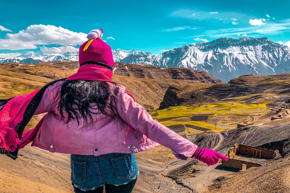 Woman standing on cliff overlooking the vast ranges at Komic