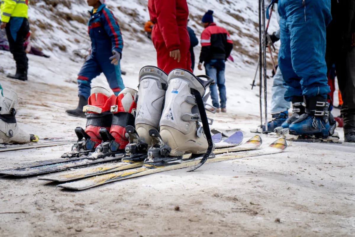 Low shot of sking boots on skis in snow showing crowd of people