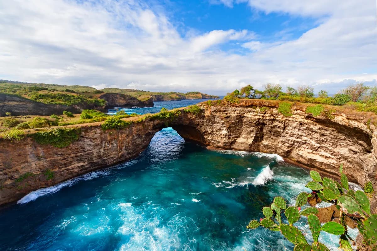 Natural stone bridge over sea pool in Broken Bay beach in Nusa Penida island