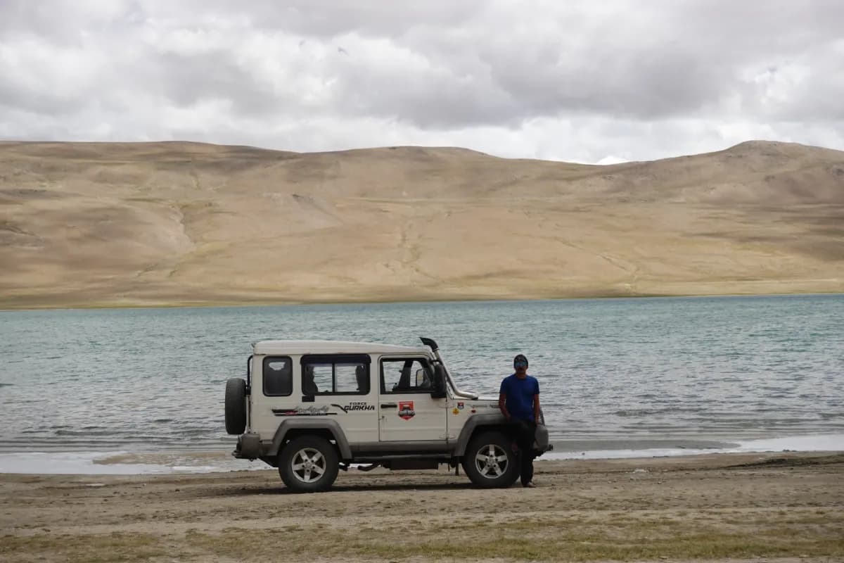 SUV Car 4x4 In Mountains ove a Beautiful Lake in Ladakh, Tso Moriri Lake