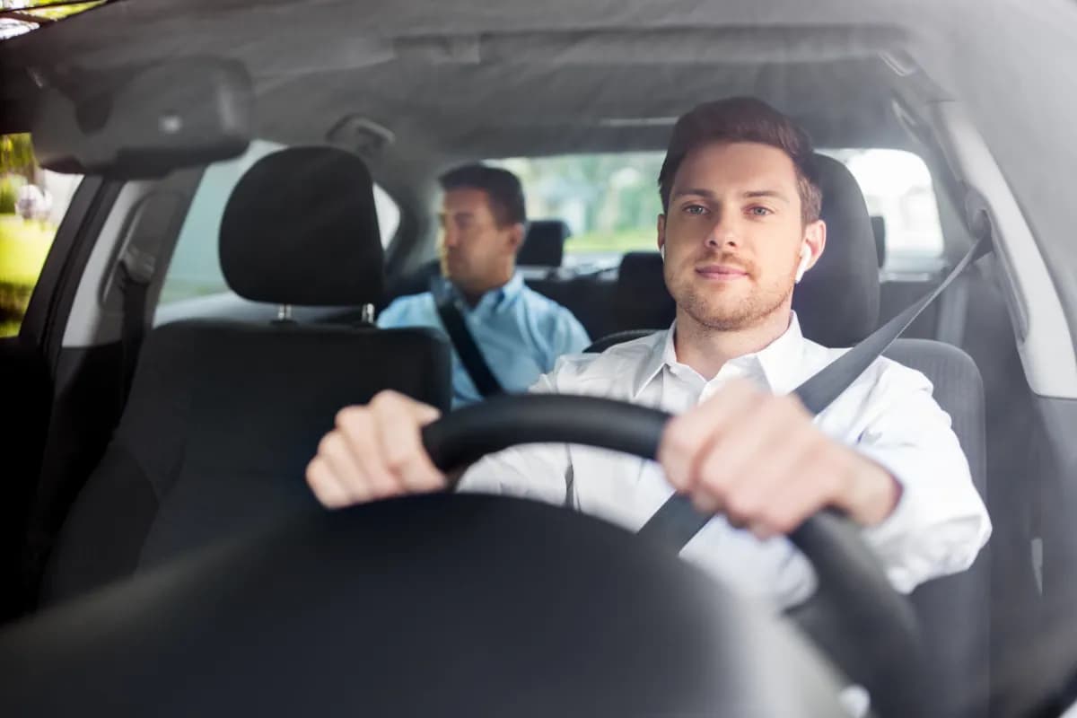 male driver with wireless earphones with a Passenger